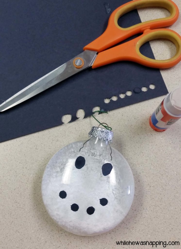 Snowman Ornament cut eyes from construction paper and glue onto glass ball